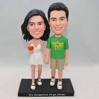 Sweet lovers bobbleheads with a red heart-shaped in girl's hand