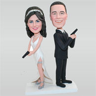 Funny groom in black suit and bride in white wedding dress holding a gun custom bobbleheads