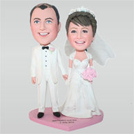 Groom in white suit and bride in white wedding dress holding a bunch of flowers custom bobbleheads