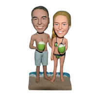 Bikini couple handing a coconut on the beach bobblehead