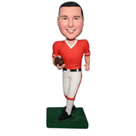 Man in sports wear handing with a football bobblehead