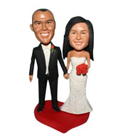 Groom in black suit and bride in white wedding dress handing a bunch of flowers custom bobblehead