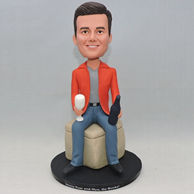 Orange jacket bobblehead sitting on the chair