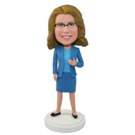 A middleaged female in light blue shirt, skirt and blue suitcoat bobble heads